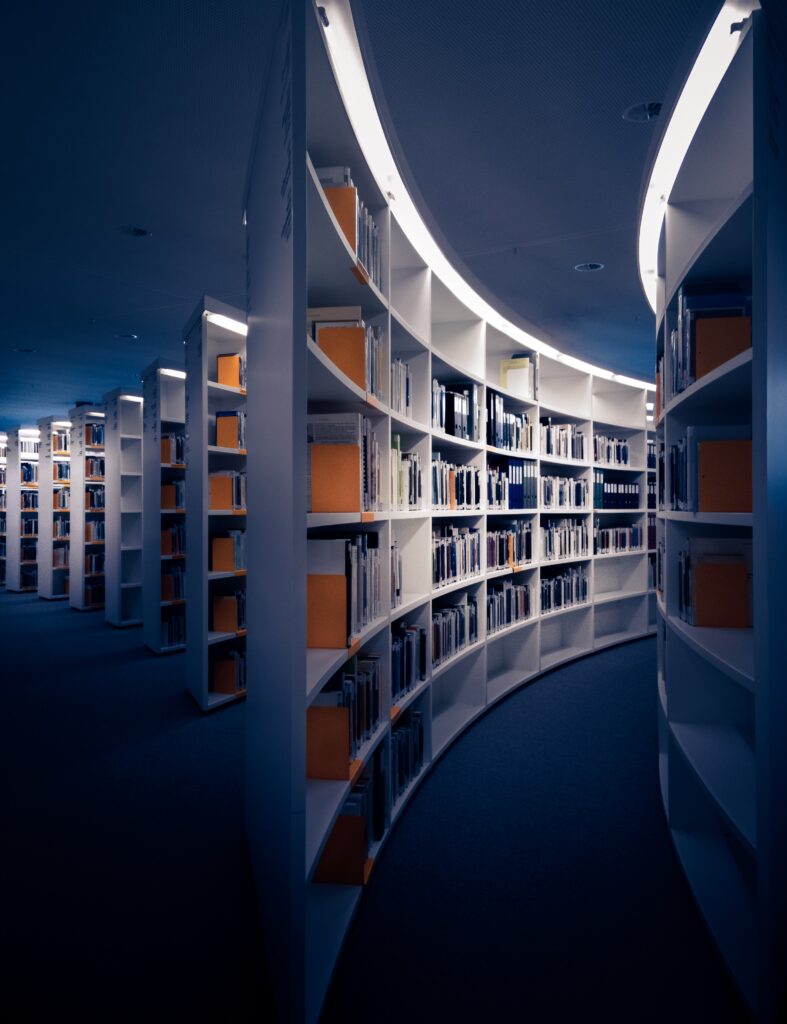 A Library with white bookshelves taken from an angle that makes it look infinite.